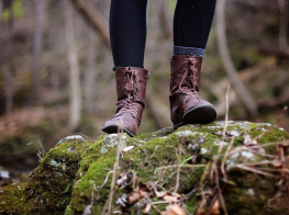Cilvēka kājas ar pārgājiena apaviem brīvdabā