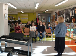 Cilvēki gaišā telpā pasākuma laikā