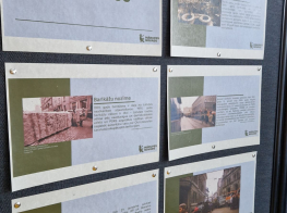 Tumša fona stends ar izstādes plakātiem