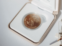 Monēta gaišā kastītē uz gaiša fona