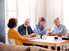 Seniori sēž pie galda