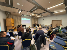 Cilvēku grupa gaišā telpā sanāksmes laikā