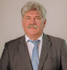 Vīrietis uzvalkā uz gaiša fona